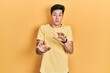 © Krakenimages.com - Young hispanic man wearing casual yellow t shirt afraid and terrified with fear expression stop gesture with hands, shouting in shock. panic concept.