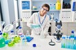 © Krakenimages.com - Young hispanic woman wearing scientist uniform measuring liquid at laboratory