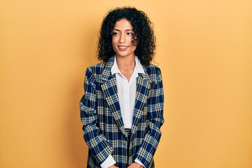 Wall Mural - Young latin girl wearing business clothes looking away to side with smile on face, natural expression. laughing confident.