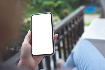 Sticker - Cell phone mockup image blank white screen.  Woman hand holding, using mobile phone at home.