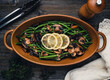 Cooked green beans and mushrooms in an oval dish.