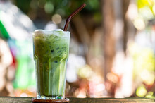 Iced Green Matcha Tea In Glass With Green Outdoor Background
