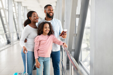 Wall Mural - Black family travelling, waiting for the aircraft arrival