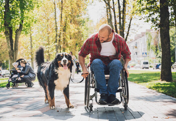 Wall Mural - Happy young man with a physical disability who uses wheelchair with his dog.