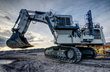 Big excavator in coal mine at cloudy day, low angle view