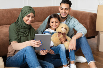 Wall Mural - Arab family using digital tablet in their new apartment