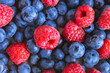 Fresh berry background. Texture of mixture raspberry and blueberry berries close up. Flat lay, top view