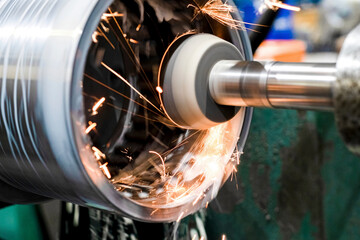 Internal grinding of a part on a CNC machine from which there are a lot of sparks and coolant.