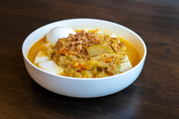 Wall Mural - A plate of Indonesian food with vegetable curry, boiled egg and lontong rice