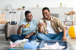 © Prostock-studio - African Travelers Couple Using Smartphone And Credit Card At Home