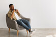 © Prostock-studio - Black Man Enjoying Coffee Sitting In Chair On Gray Background