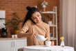 © Pixel-Shot - Beautiful woman drinking tea and talking by phone at home