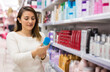 © caftor - Young Latina choosing haircare cosmetics in specialized boutique