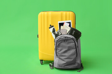 Sticker - Packed backpack and suitcase with travelling belongings on color background