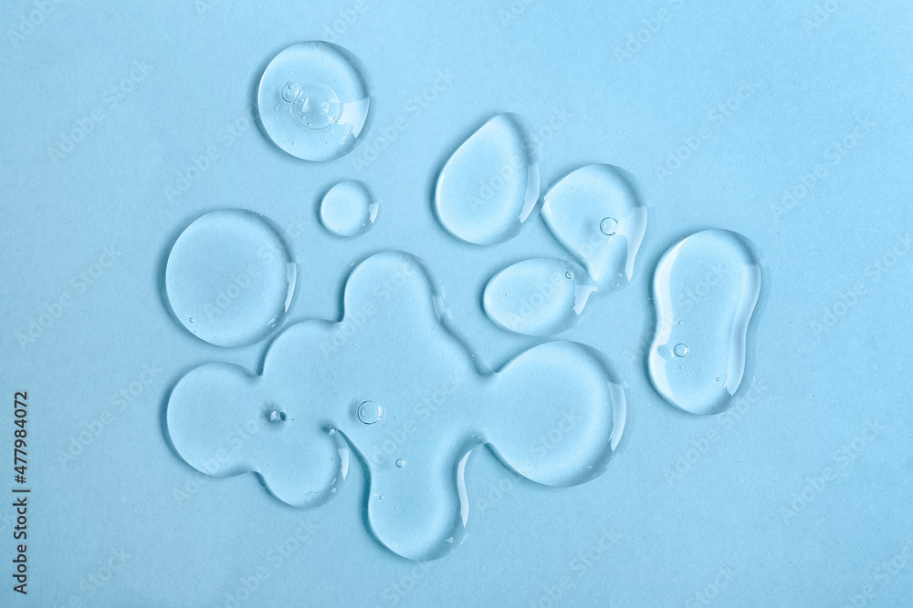 Drops of liquid transparent gel on blue background