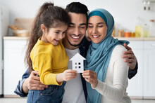 Happy Islamic Family With Little Daughter Holding Cutout Paper House Figure