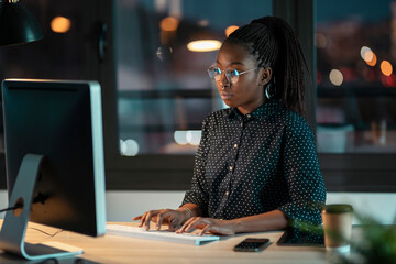 Wall Mural - Pretty happy entrepreneur woman working with laptop sitting in the office.