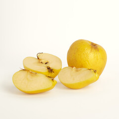 Wall Mural - Shriveled yellow apples on a white background. One apple is crushed into pieces. Selective focus. Ugly food concept.