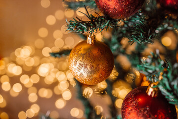 Happy new year 2024 theme with xmas red and gold balls decoration on Christmas tree branch over beautiful lights background. Selective focus