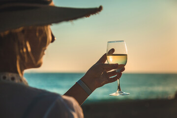 Wall Mural - Wine glasses at sunset on the beach. Selective focus.