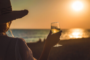 Wall Mural - Wine glasses at sunset on the beach. Selective focus.