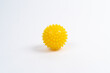yellow ball of a massage needle on a white background, the concept of prevention of flat feet, hallux valgus, copy space