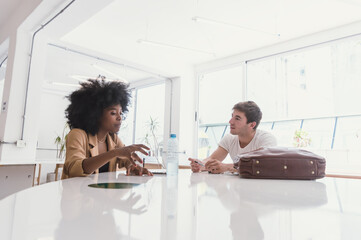 Black Latina Girl With Afro And Latino Caucasian Boy Sitting talking