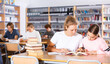 © JackF - Two female friends reading books together and preparing for exams in the school library