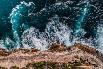 stylized long exposure drone shot of shelly headland waves