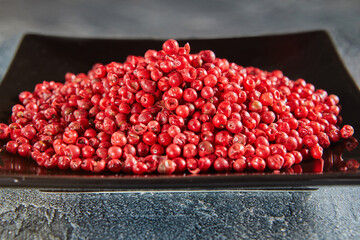 Poster - Red peppercorns on black plate with reflection