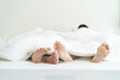 © Kawee - Close up feet of male gay couple lying down on bed, cover with blanket