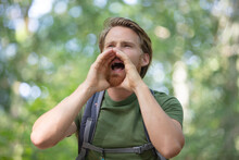 Young Man Screaming Outdoors In Forest