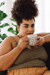 Wall Mural - Woman drinking coffee and looking at camera