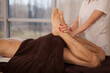 Unrecognizable man getting professional legs massage at spa center
