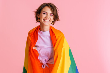 Wall Mural - White brunette woman smiling while posing with rainbow flag