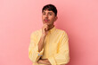 © Asier - Young mixed race man isolated on pink background suspicious, uncertain, examining you.