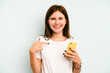 © Asier - Young English woman holding mobile phone isolated on blue background person pointing by hand to a shirt copy space, proud and confident