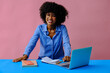 © Carlos David - happy young african american black entrepreneur student businesswoman using laptop and smiling at camera