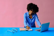 © Carlos David - attractive young african american black entrepreneur student businesswoman using laptop and taking notes at workplace
