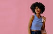 © Carlos David - attractive black girl in eyeglasses with backpack posing on pink background, back to school concept