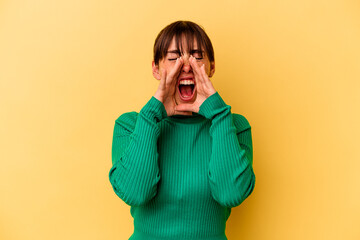 Young Argentinian woman isolated on yellow background shouting excited to front.