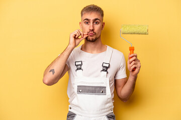 Wall Mural - Young painter man isolated on yellow background with fingers on lips keeping a secret.