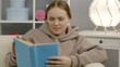© FetViewRoom - A cute girl is sitting on the couch and reading a fascinating book. Education during quarantine.