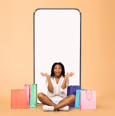 Woman posing with white empty smartphone screen and shopper bags