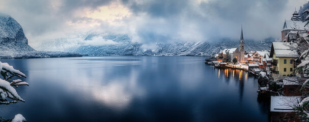 Wall Mural - Panoramic view of the lake and village of Hallstatt during a winter day with snow and ice in the Austrian Alps