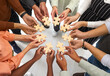 © Studio Romantic - Business and cooperation. Multiracial people stand in circle and connect wooden pieces of puzzles they hold in their hands. Cropped image of hands holding puzzle pieces symbolizing unity and teamwork.