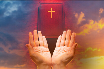 Wall Mural - Praying hands. Catholic religion. Religious Christian praying to God. Open palms next to bible. Holy book of Christians on background of heaven. Confessions of Christianity. Orthodox religious ritual