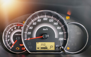 Close-up of the engine, the car's speedometer and the amount of fuel. Cheap oil concept. Hurry to fill up the tank.