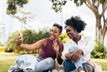 Smiling Black Women Taking Selfie On Lawn
