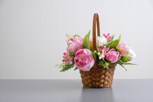 Beautiful Bouquet Of Pink Peonies. Floral Composition In Straw Basket On Light Gray Background